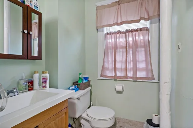 a bathroom with a sink a toilet and a window