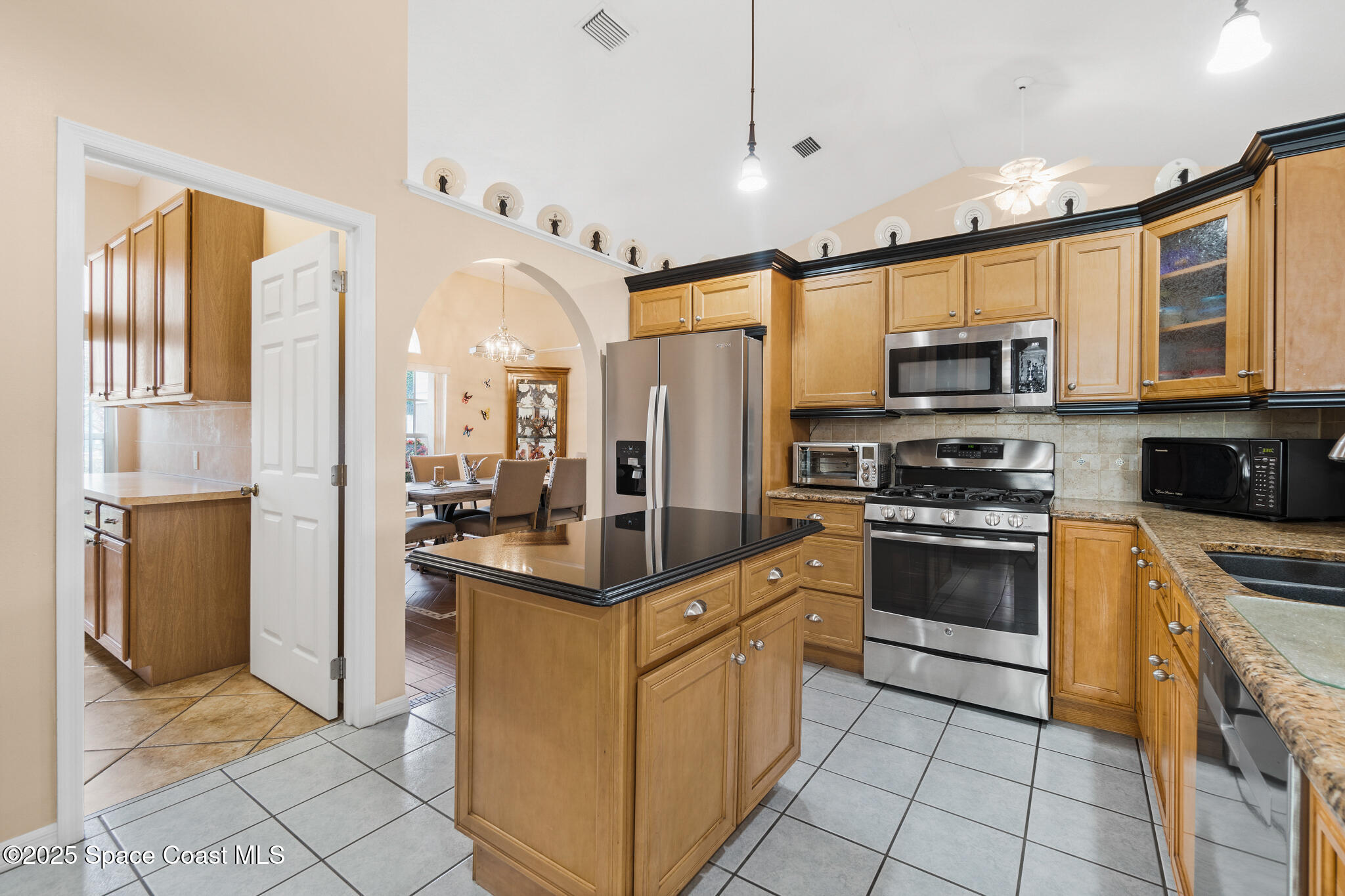 4808 Springwater Circle Melbourne, FL 32940 - Photo 11 of 38 a kitchen with stainless steel appliances granite countertop a stove top oven a refrigerator and a sink