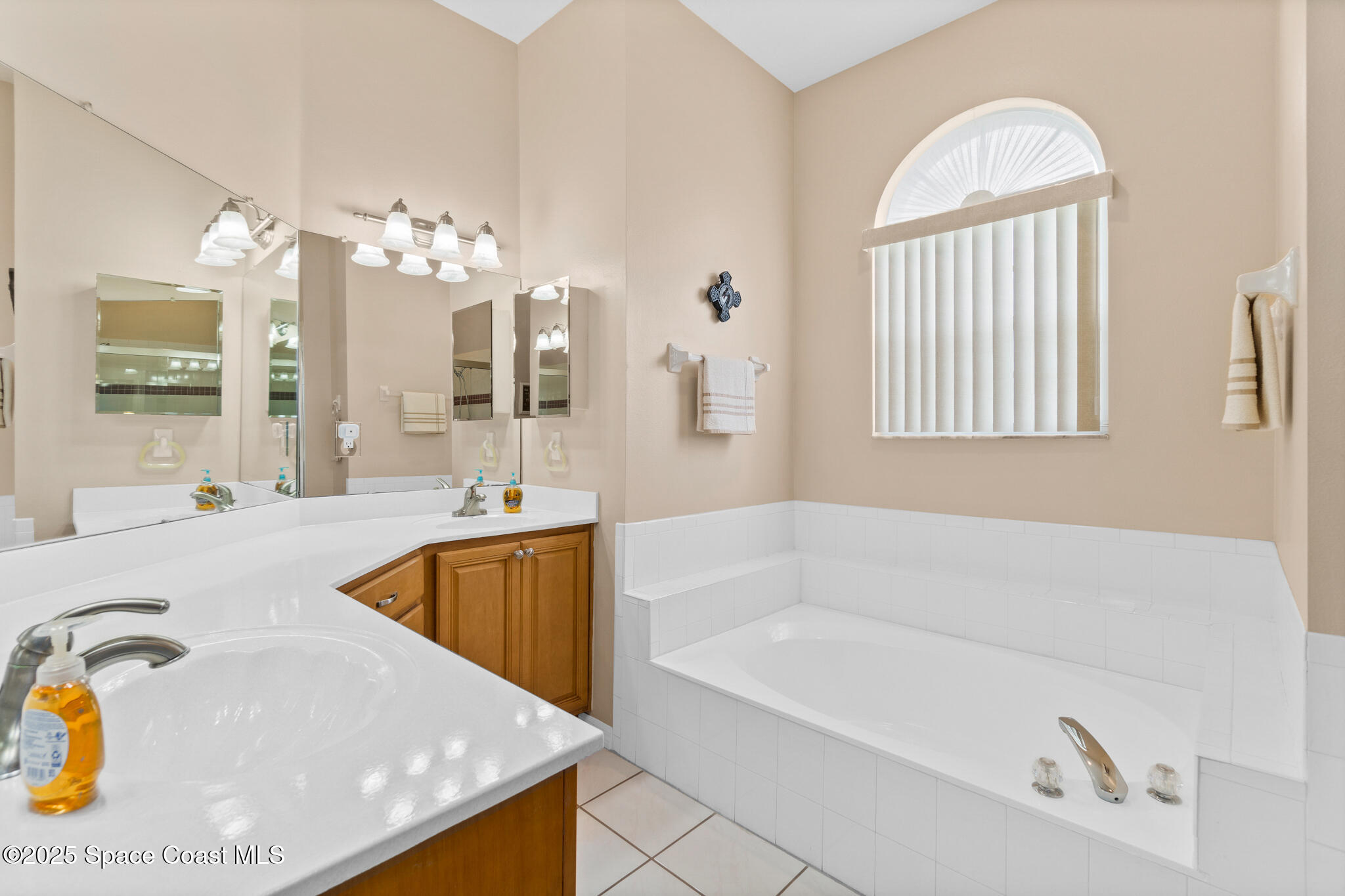 4808 Springwater Circle Melbourne, FL 32940 - Photo 17 of 38 a spacious bathroom with a tub a double vanity sink a mirror a window and a bathtub