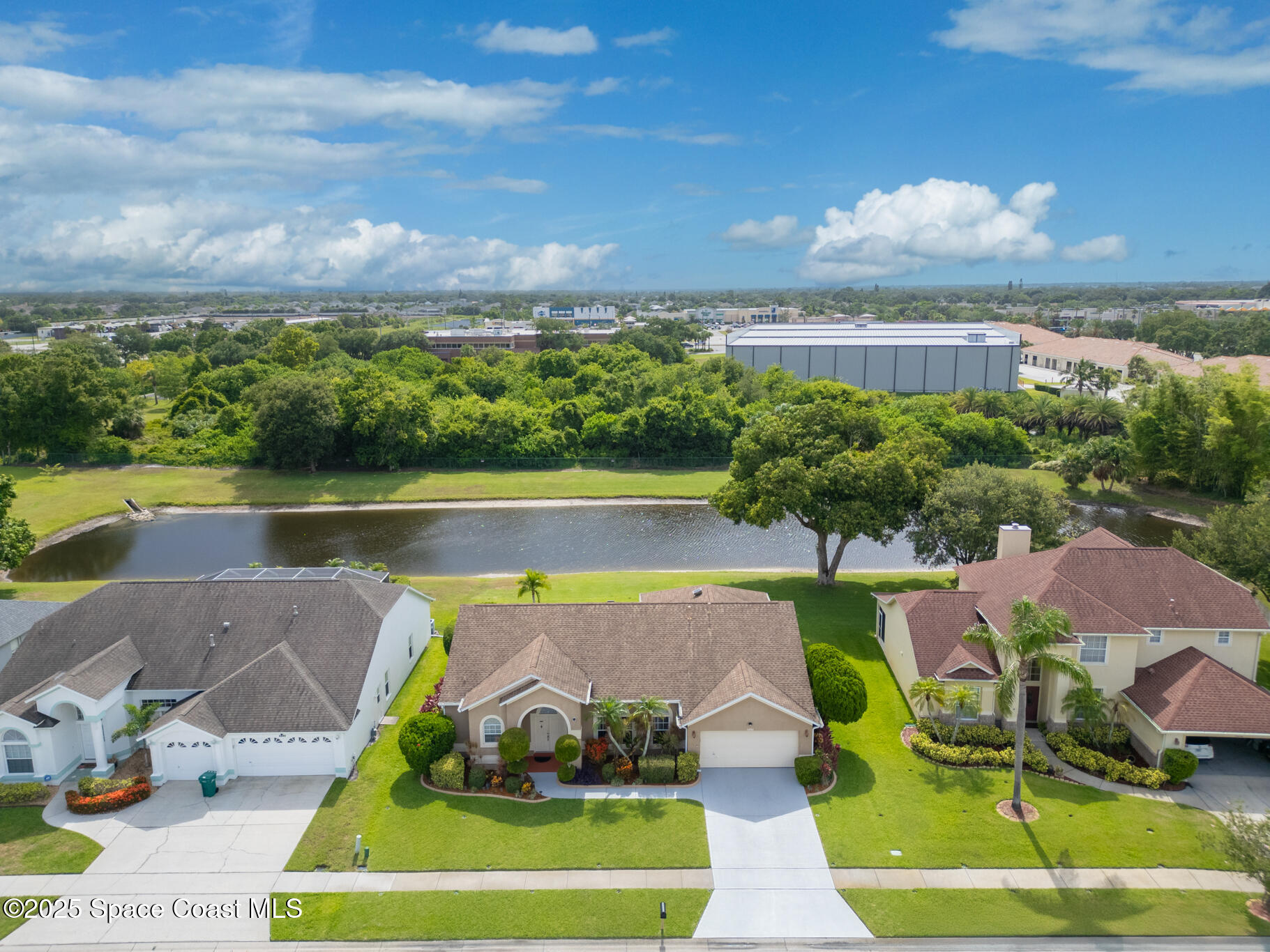 4808 Springwater Circle Melbourne, FL 32940 - Photo 2 of 38 a view of a lake with a garden and houses