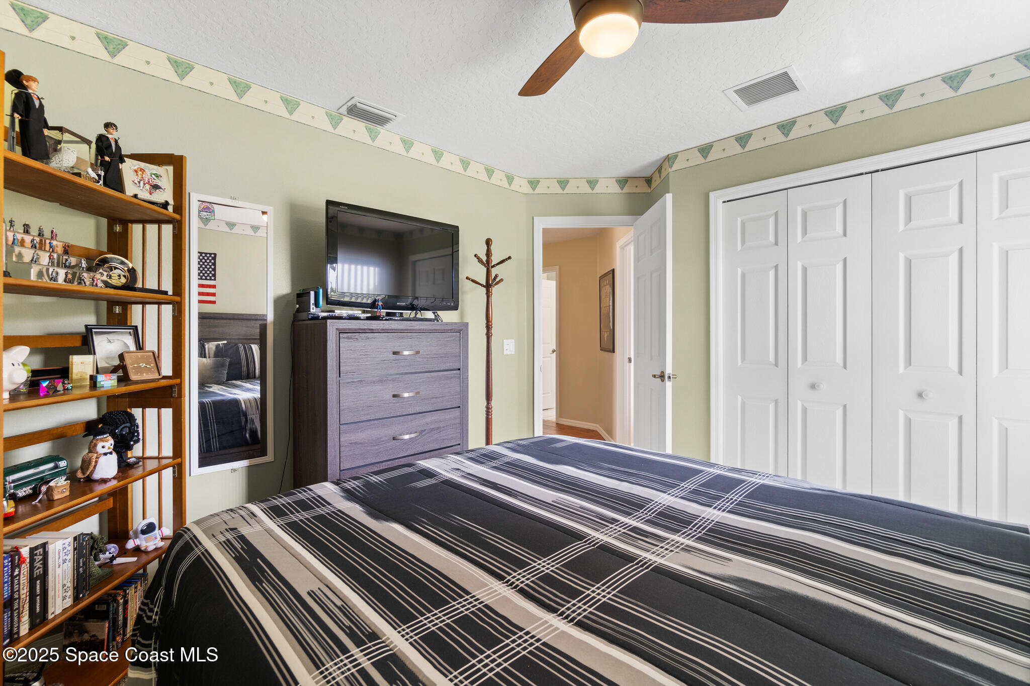 4808 Springwater Circle Melbourne, FL 32940 - Photo 21 of 38 a bedroom with a bed and a book shelf
