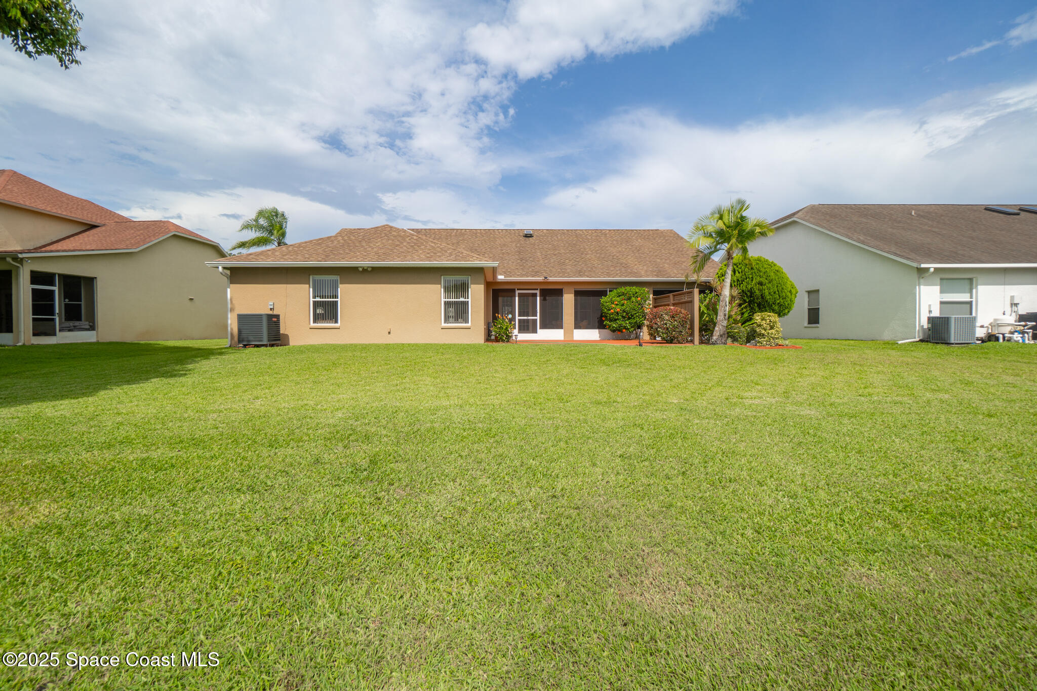 4808 Springwater Circle Melbourne, FL 32940 - Photo 29 of 38 a view of a house with a big yard and palm trees