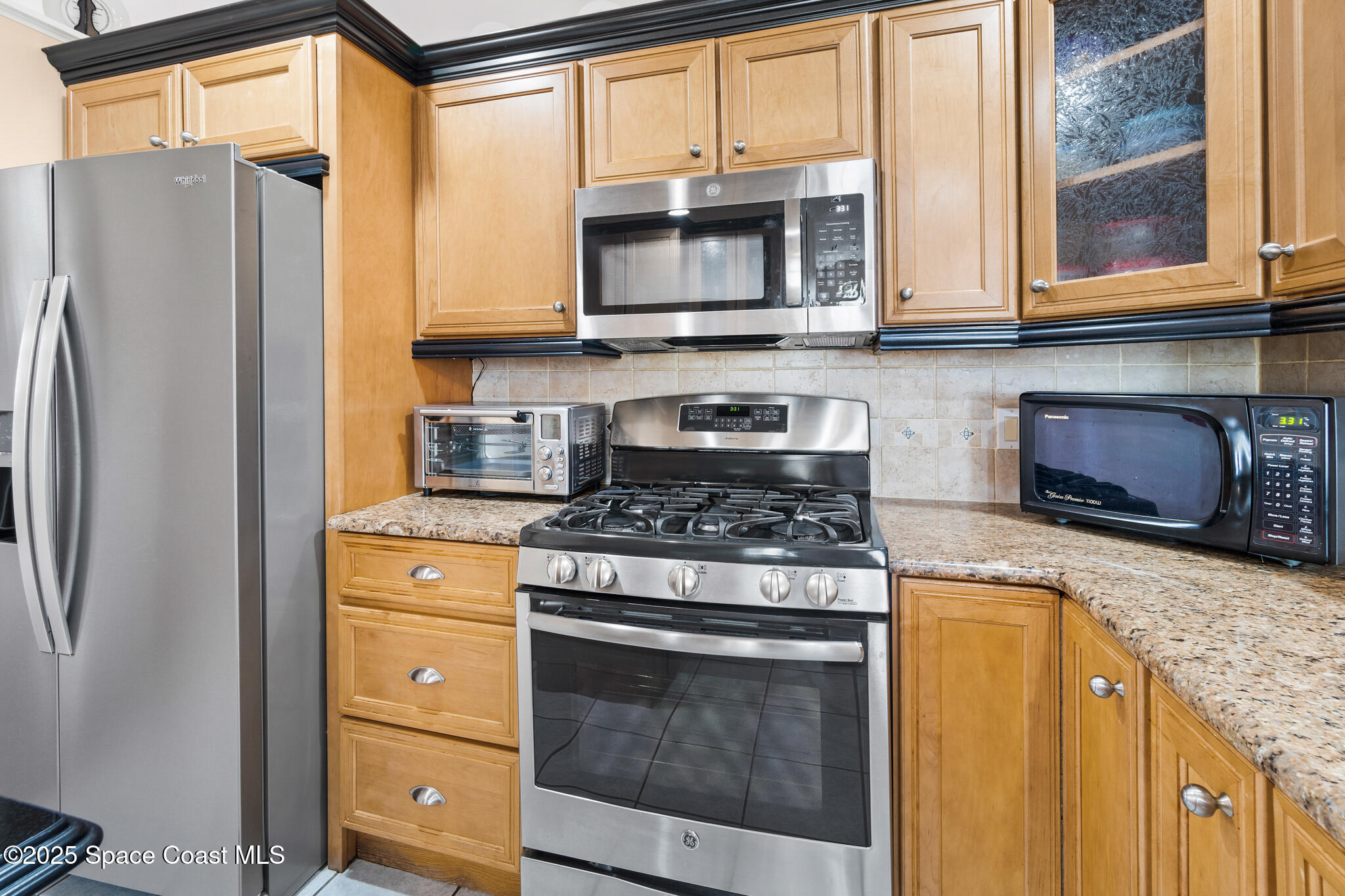 4808 Springwater Circle Melbourne, FL 32940 - Photo 3 of 38 a kitchen with stainless steel appliances granite countertop a stove a refrigerator and a microwave
