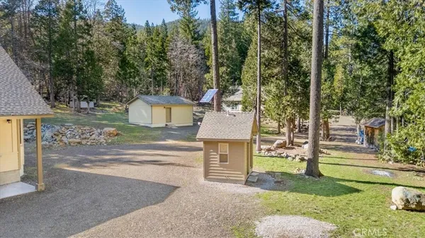 front view of a house with a yard and an trees