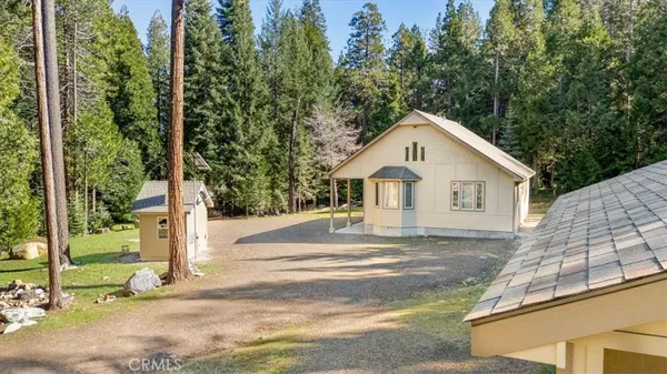 a view of a house with backyard and trees
