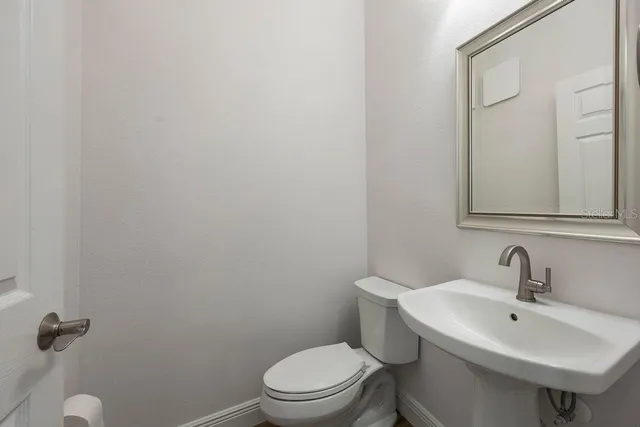 a bathroom with a sink a toilet and a mirror