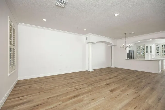 a view of empty room with wooden floor and windows