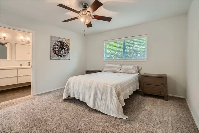a spacious bedroom with a bed and a ceiling fan
