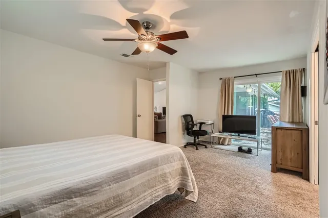 a bedroom with a bed window and a flat screen tv