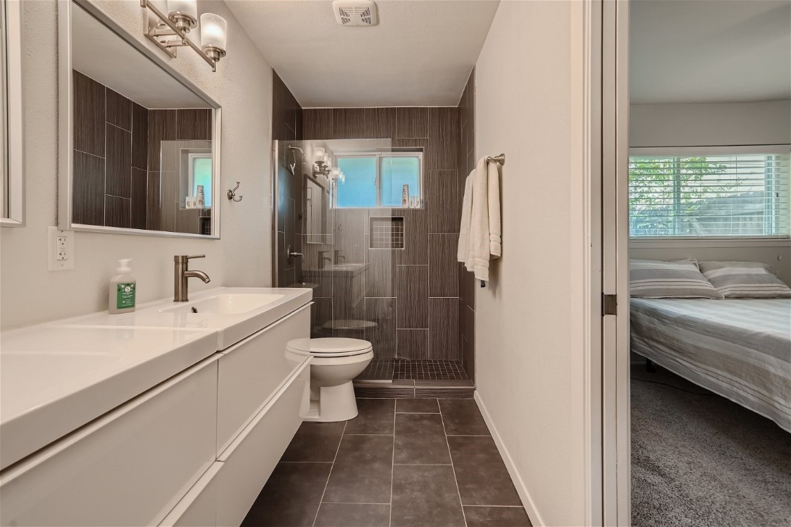 6614 Ashland Drive Austin, TX 78723 - Photo 17 of 28 a bathroom with a sink a toilet and a shower