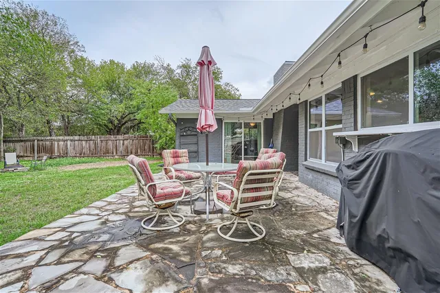 a view of a patio with table and chairs near a barn