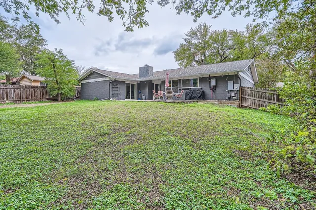 a view of a house with a big yard and large trees