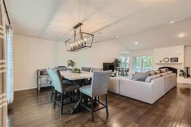 a living room with furniture a dining table and a chandelier