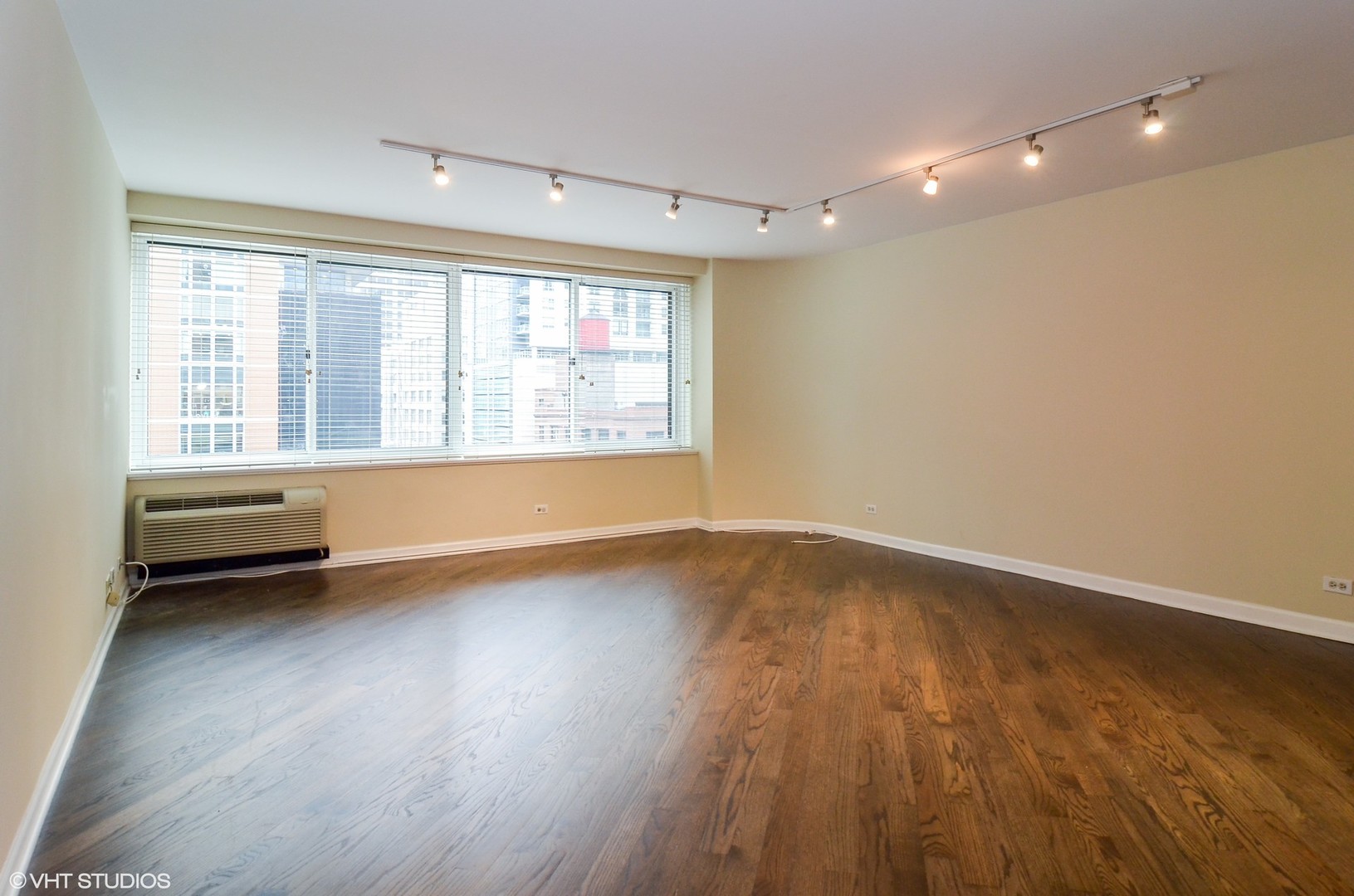 211 East Ohio Street, Unit 809 Chicago, IL 60611 - Photo 4 of 17 an empty room with wooden floor and windows