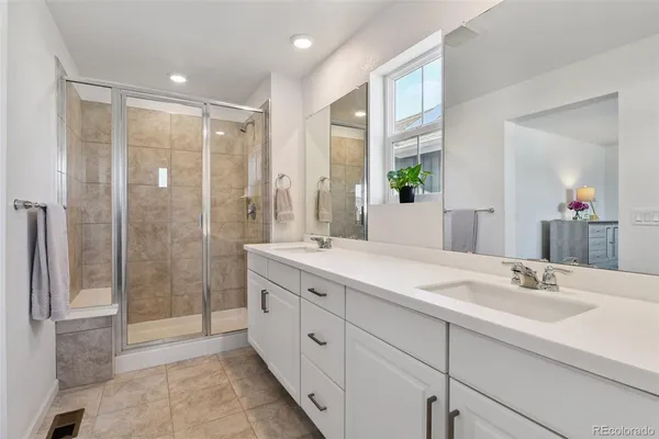 a bathroom with a double vanity sink mirror and shower