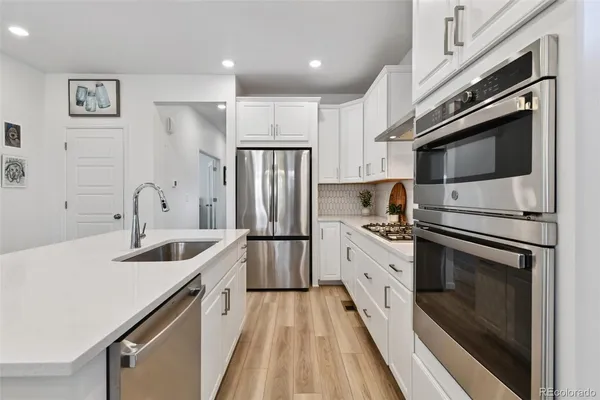 a kitchen with stainless steel appliances a refrigerator sink and microwave