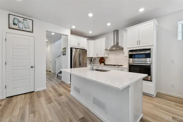 a kitchen with kitchen island a sink stainless steel appliances and cabinets