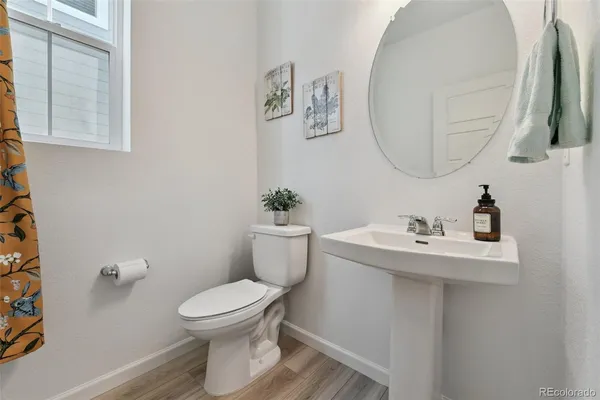 a bathroom with a toilet a sink and mirror