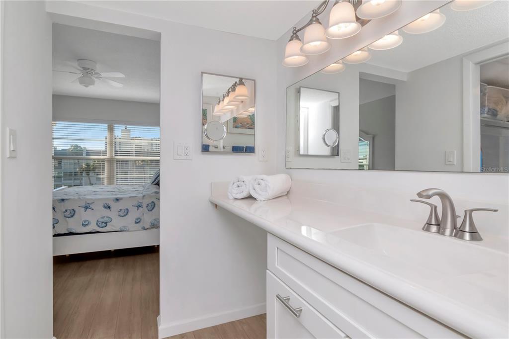 4390 Exeter Drive, Unit 305 Longboat Key, FL 34228 - Photo 23 of 78 a bathroom with a sink a vanity and mirror