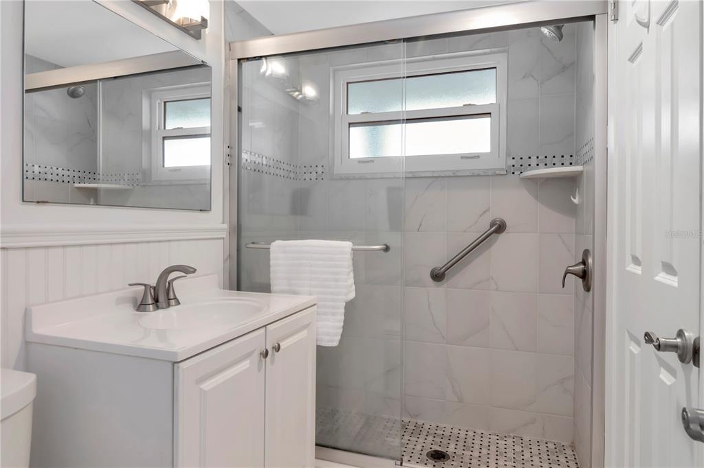 4390 Exeter Drive, Unit 305 Longboat Key, FL 34228 - Photo 25 of 78 a bathroom with a sink a mirror and shower