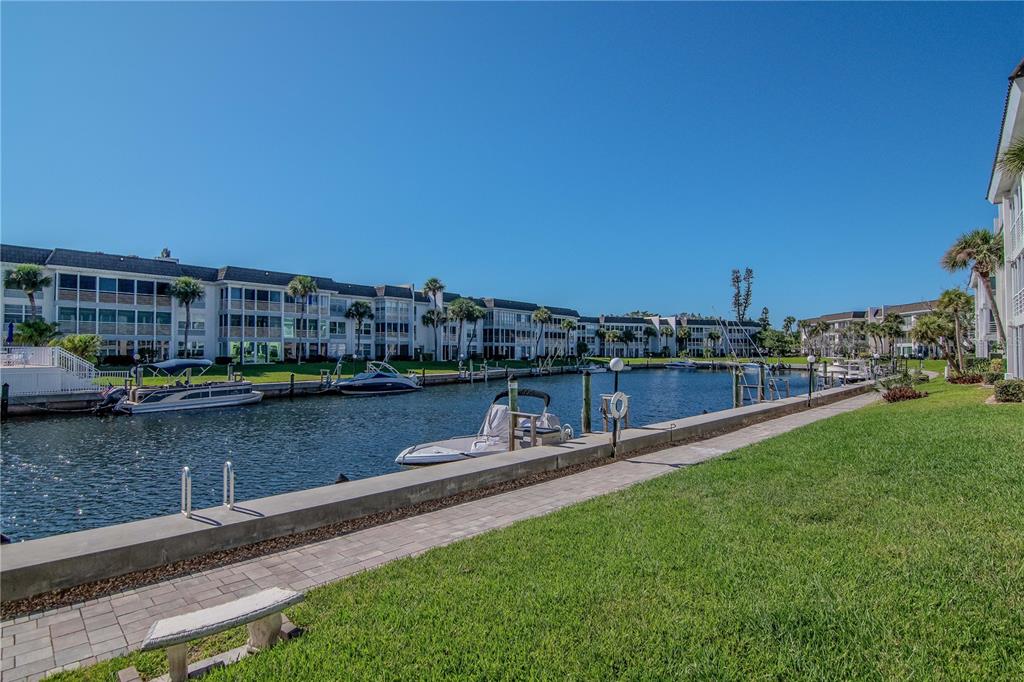 4390 Exeter Drive, Unit 305 Longboat Key, FL 34228 - Photo 71 of 78 a view of a lake with a yard and large trees