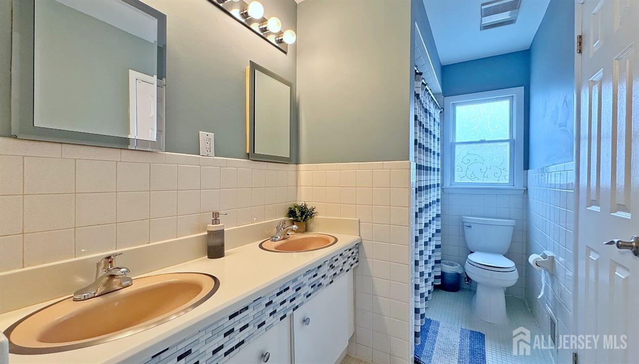 19 Norton Street Edison, NJ 08820 - Photo 22 of 29 a bathroom with a granite countertop sink a toilet and a mirror
