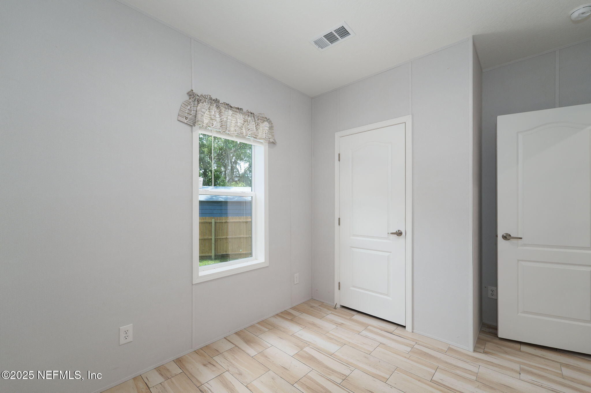 407 Sycamore Drive Macclenny, FL 32063 - Photo 19 of 25 a view of an empty room with wooden floor and a window