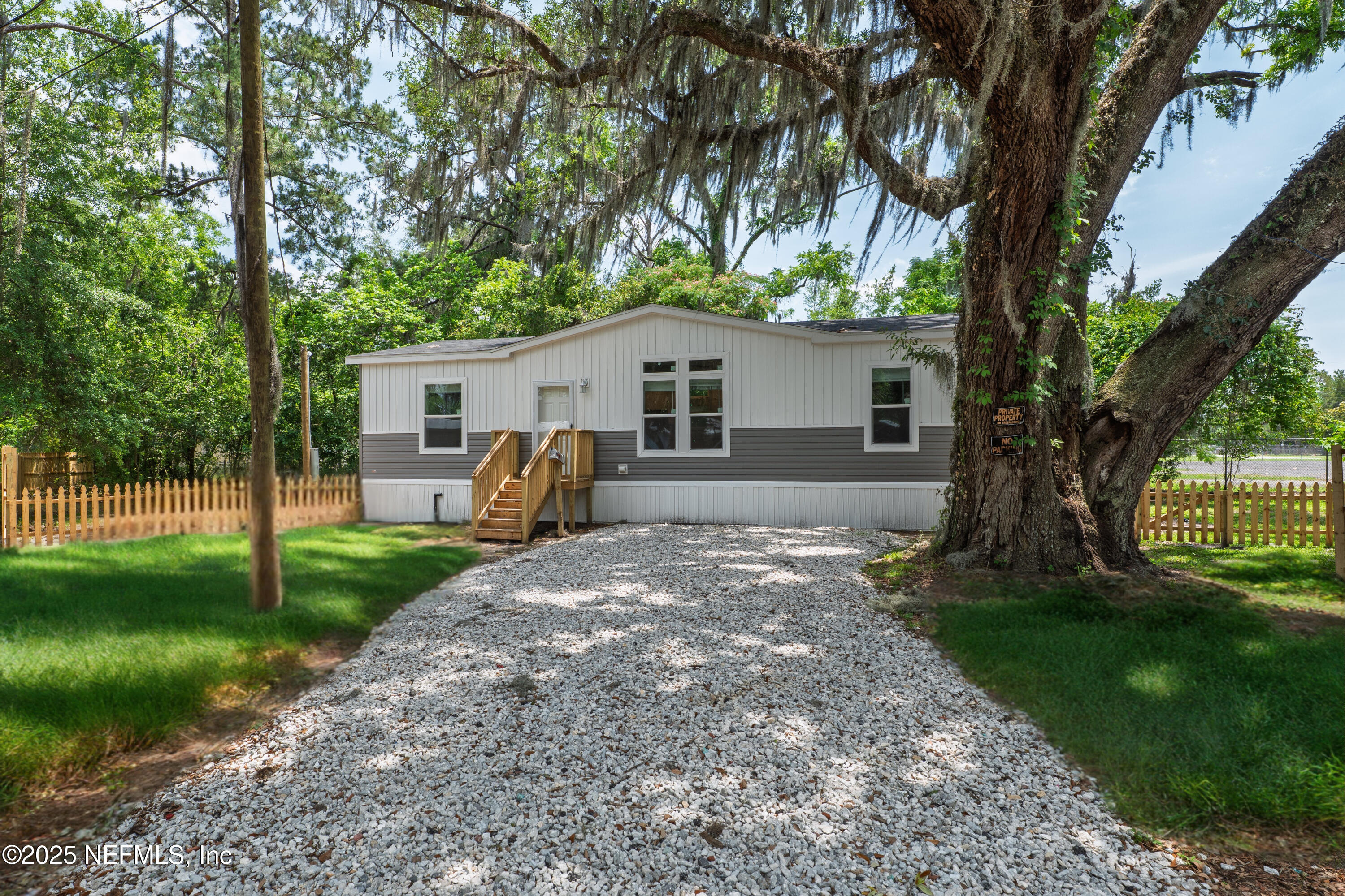 407 Sycamore Drive Macclenny, FL 32063 - Photo 2 of 25 a view of a yard in front of a house with plants and large tree