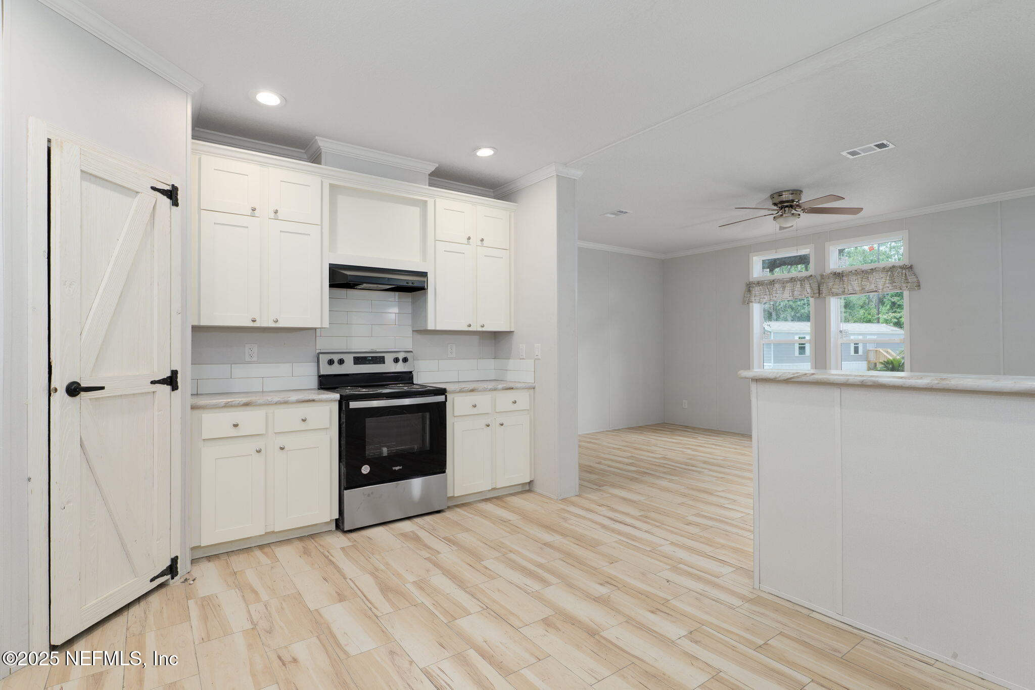 407 Sycamore Drive Macclenny, FL 32063 - Photo 3 of 25 a kitchen with granite countertop a stove a sink and a refrigerator with wooden floor