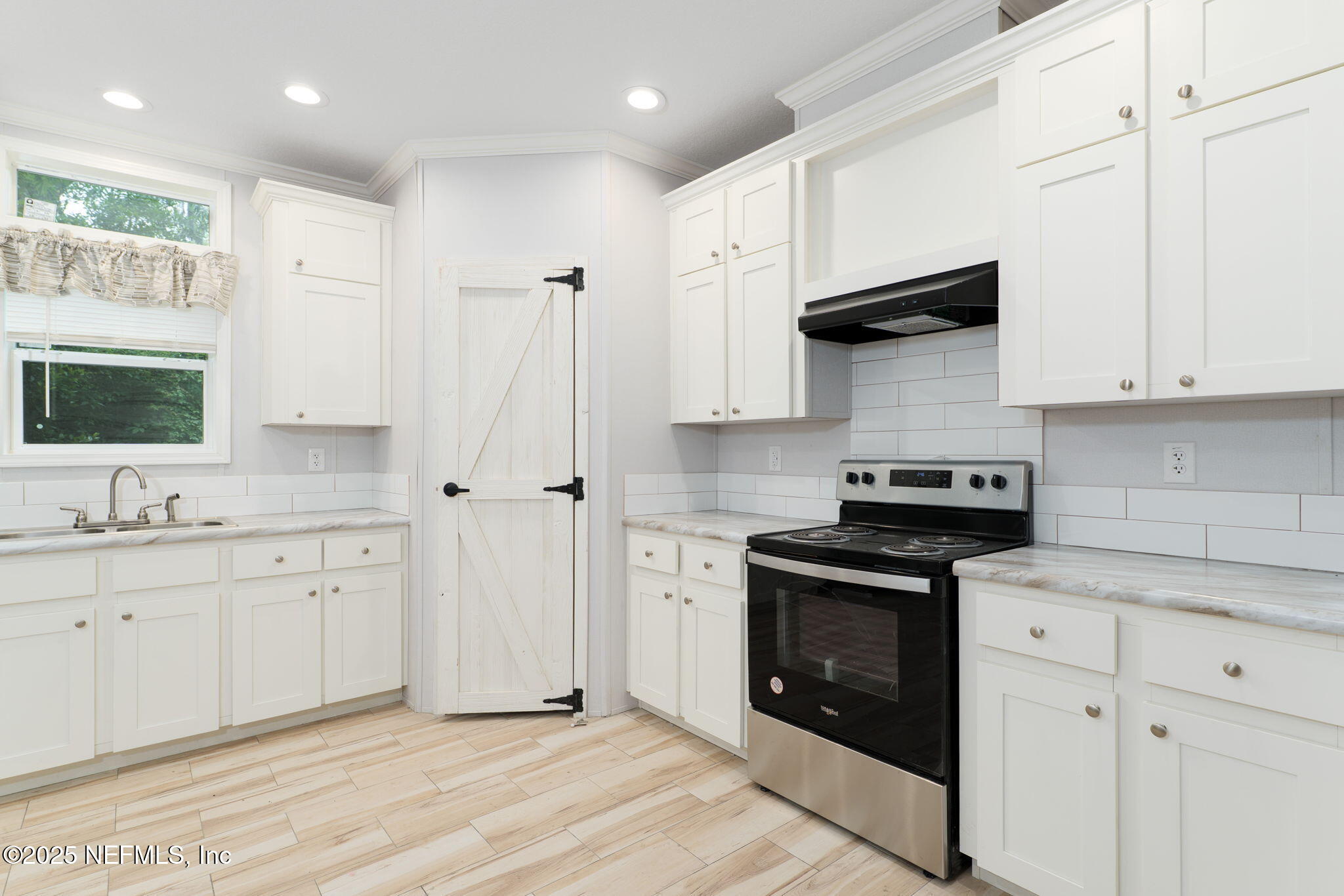407 Sycamore Drive Macclenny, FL 32063 - Photo 4 of 25 a kitchen with stainless steel appliances granite countertop a stove a sink and a microwave