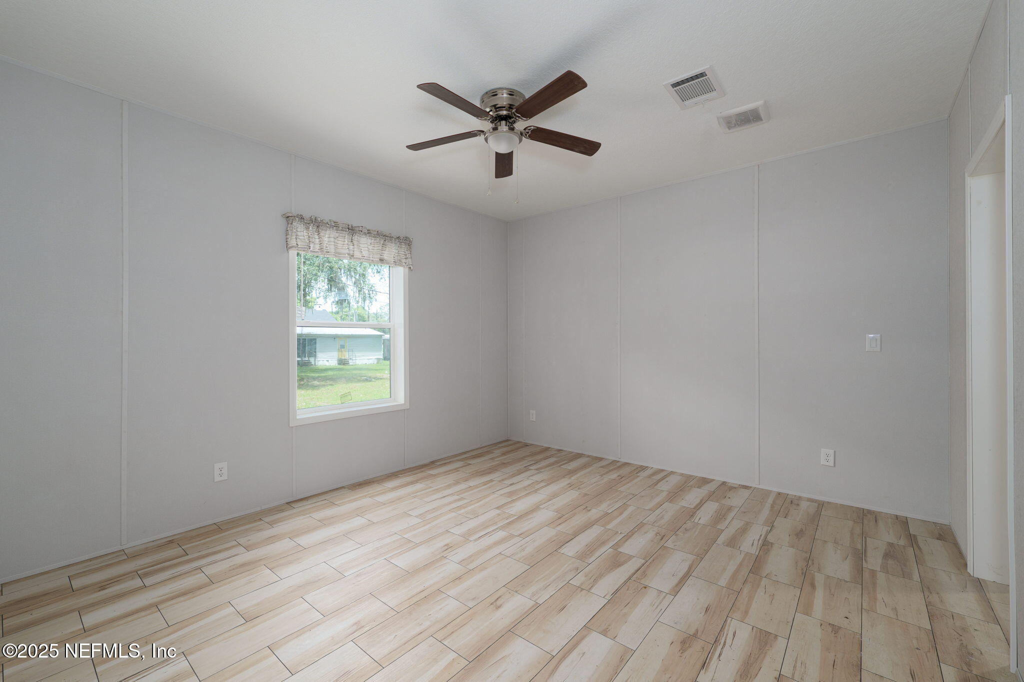 407 Sycamore Drive Macclenny, FL 32063 - Photo 10 of 25 wooden floor in an empty room with a window