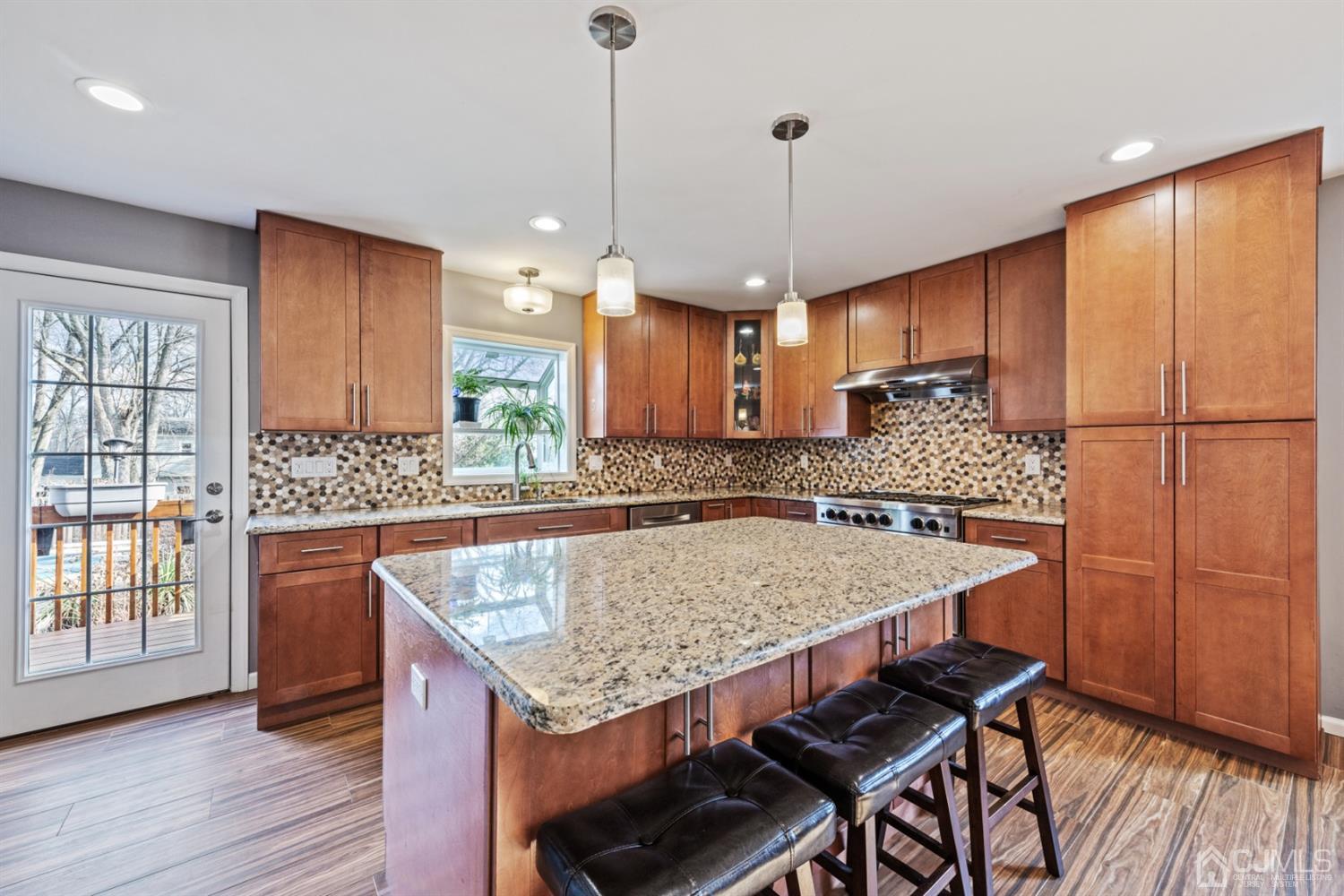 1 Jefferson Road East Brunswick, NJ 08816 - Photo 12 of 29 a kitchen with granite countertop a table chairs stainless steel appliances and wooden floor