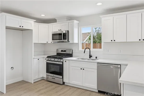 a kitchen with cabinets appliances a sink and a counter top space