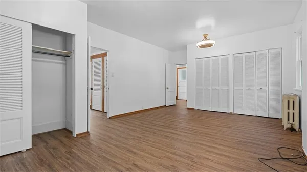 an empty room with wooden floor and closet