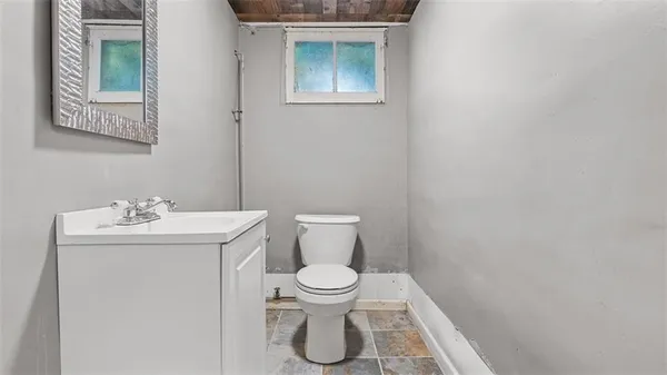 a bathroom with a toilet sink and mirror