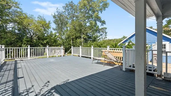 a view of deck with a large window and wooden floor