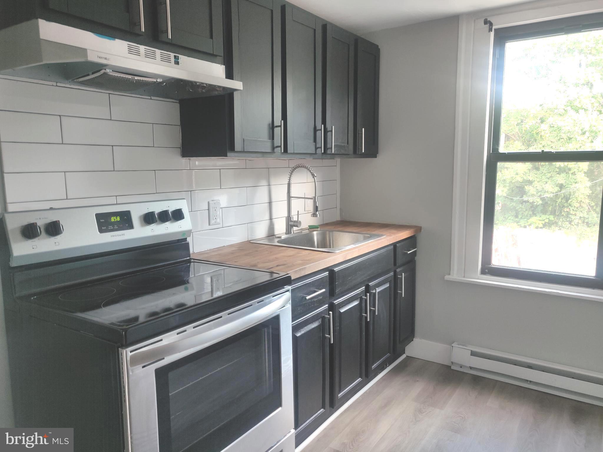4951 West Thompson Street, Unit 2R Philadelphia, PA 19131 - Photo 2 of 10 a view of a kitchen with a sink and a stove top oven