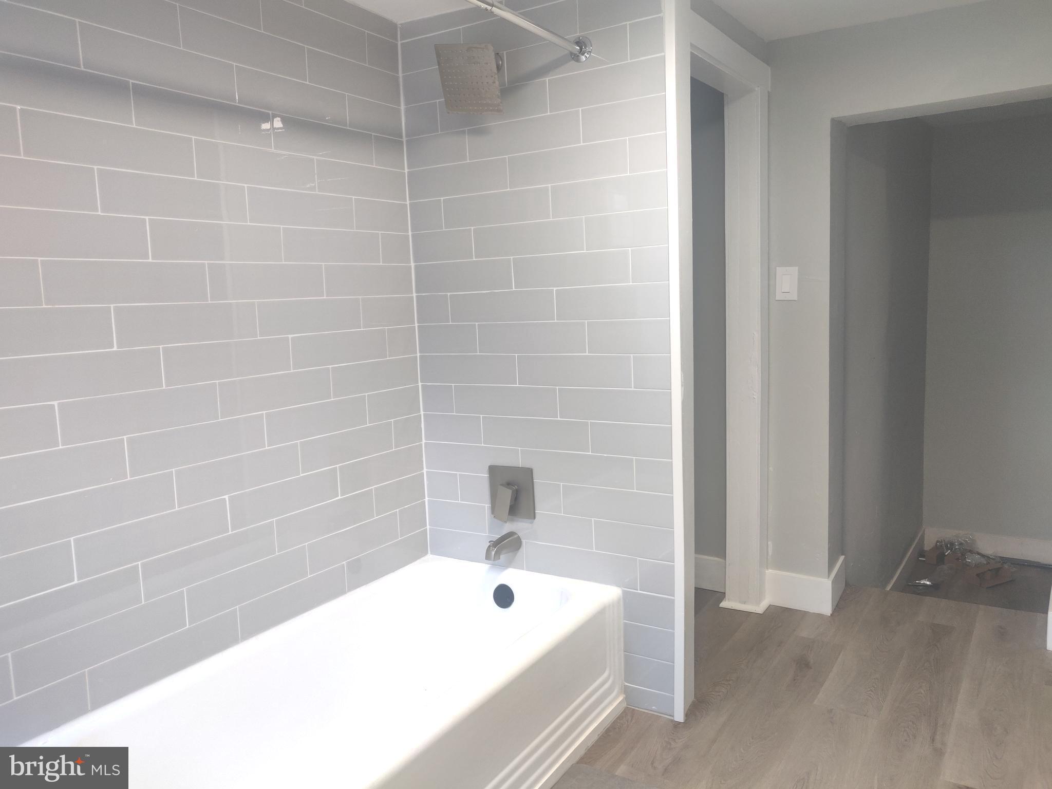 4951 West Thompson Street, Unit 2R Philadelphia, PA 19131 - Photo 5 of 10 a bathroom with a tub and a shower