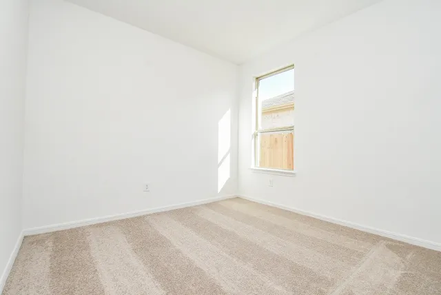 an empty room with a cabinet and a window