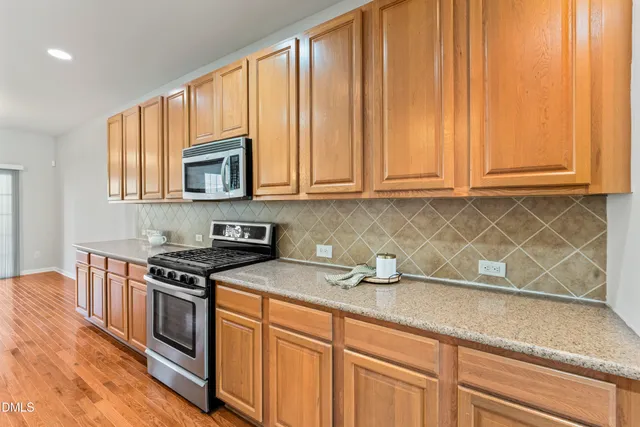 a kitchen with stainless steel appliances granite countertop a stove top oven a sink a counter space and cabinets