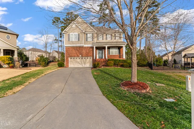 a front view of a house with a yard and fountain