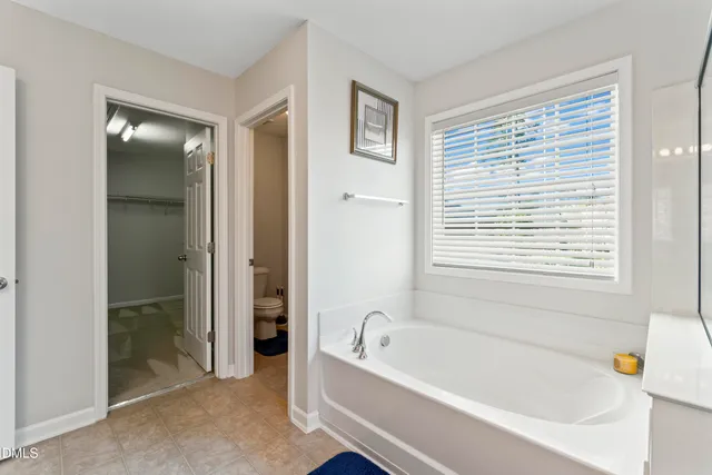a view of a big room with windows and ceiling fan