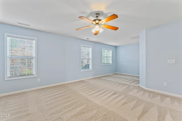 an empty room with a window and a ceiling fan