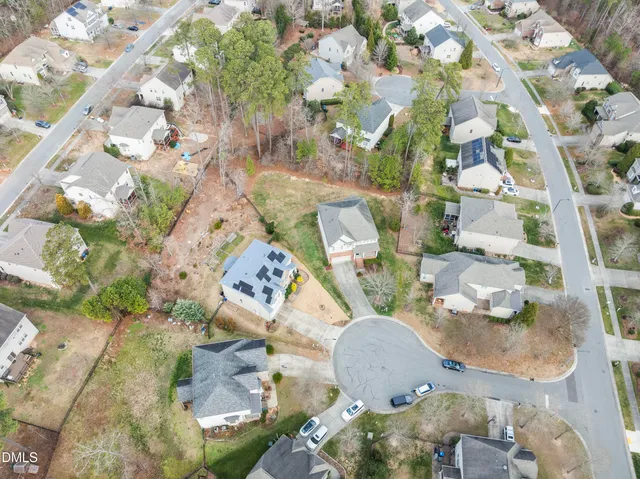 an aerial view of a house with swimming pool and large trees