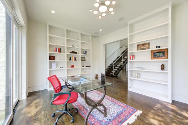 a bedroom with a large bed and wooden floor