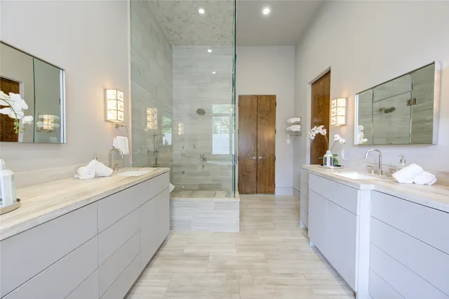 a bathroom with a tub a sink a mirror and a shower