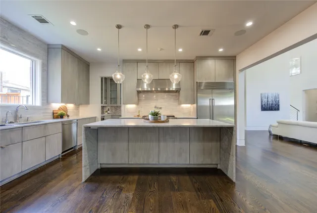 a open kitchen with kitchen island white cabinets and wooden floor