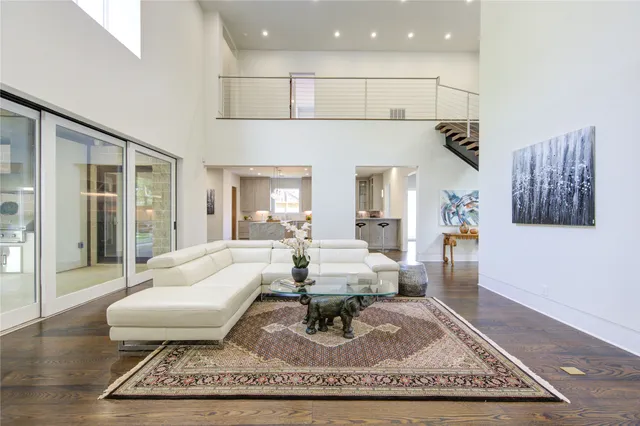 a living room with furniture a rug and a floor to ceiling window