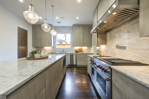 a large kitchen with kitchen island a sink dishwasher a stove and a refrigerator with wooden floor