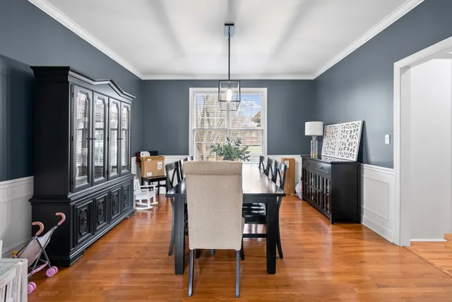 a kitchen with stainless steel appliances a stove a refrigerator a sink dishwasher and a dining table with wooden floor